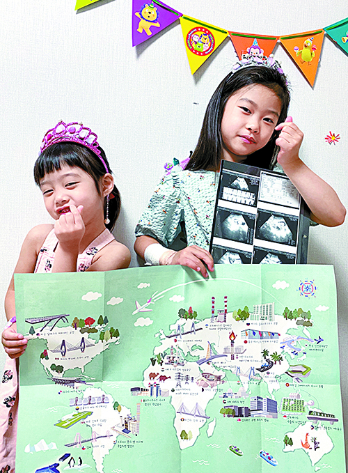 김재원 책임의 두 딸이 지도와 동생 서진양의 초음파 사진을 들고 밝게 포즈를 취하고 있다.